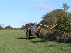 P2007A309912	A tractor cutting a hedge.