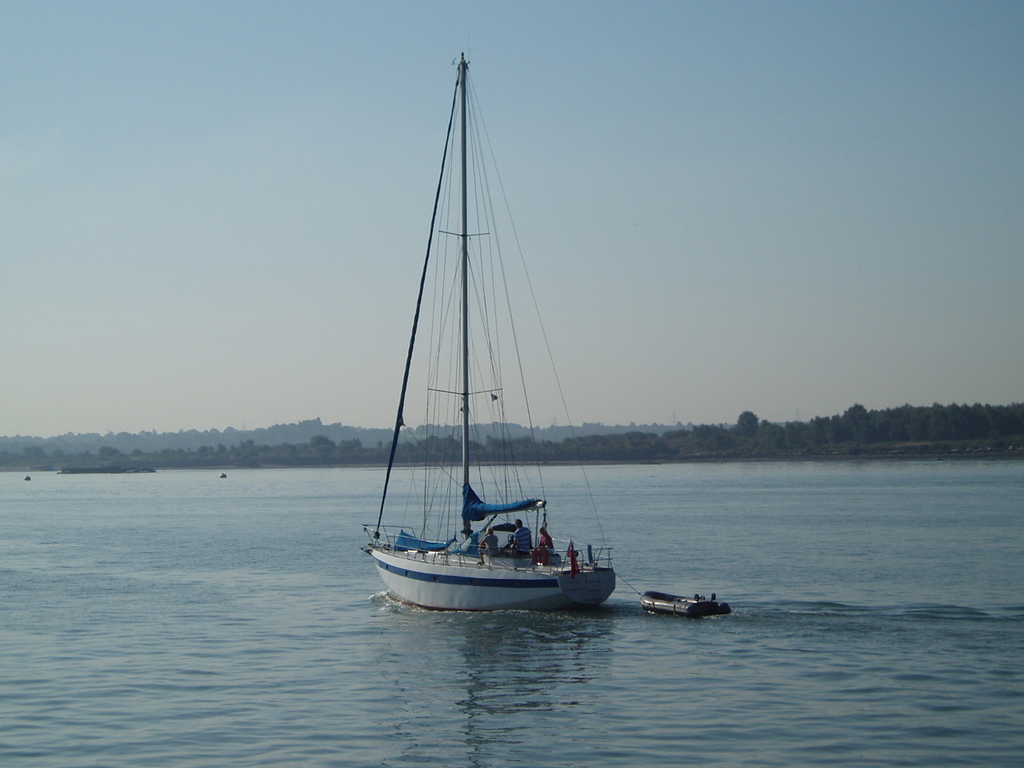A sailing boat going down the river.