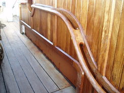P20089215399	The curved handrail leading towards the stern of the ship.