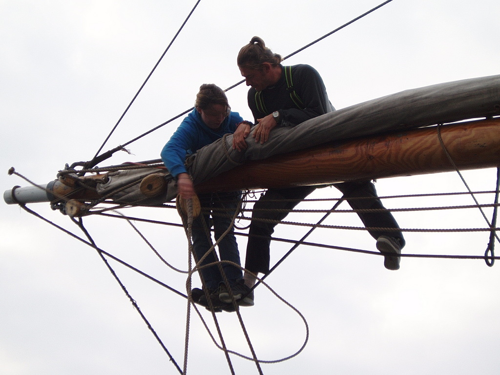 Natasha and Neil trying to tie the gaskets around the sails.