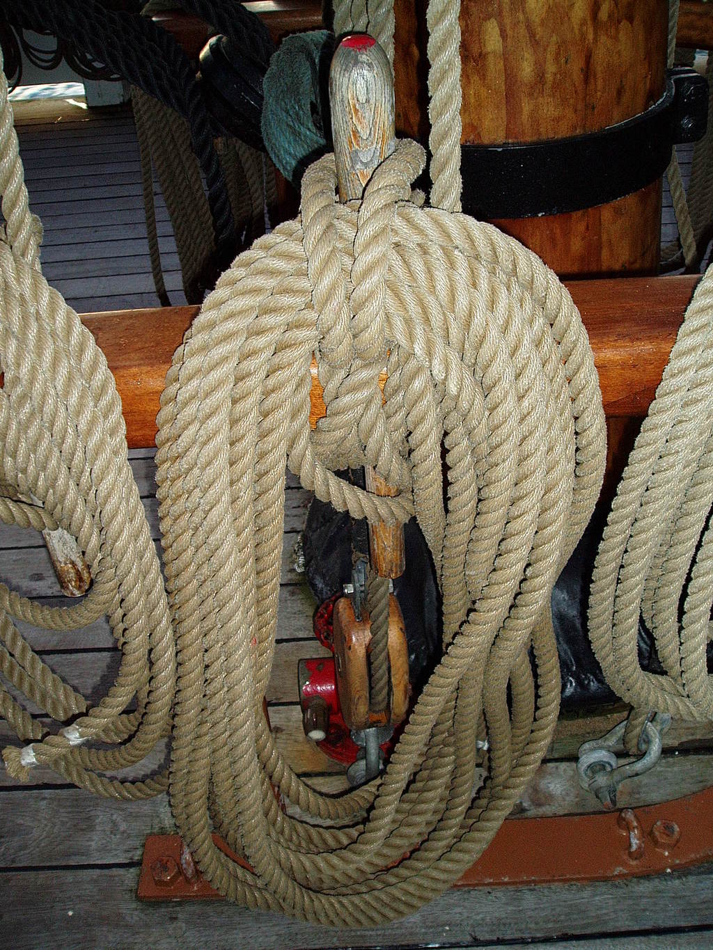 Rope coiled around a pin by the mast.